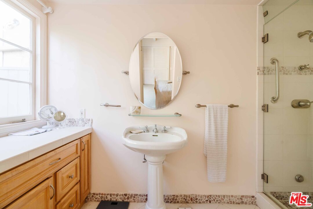 21580 Encina Road Topanga, CA 90290 - Photo 18 of 38 a bathroom with a sink a mirror and a shower