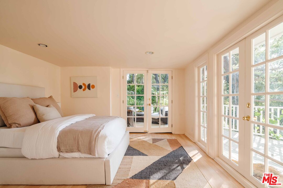 21580 Encina Road Topanga, CA 90290 - Photo 27 of 38 a bedroom with a large bed and a large window