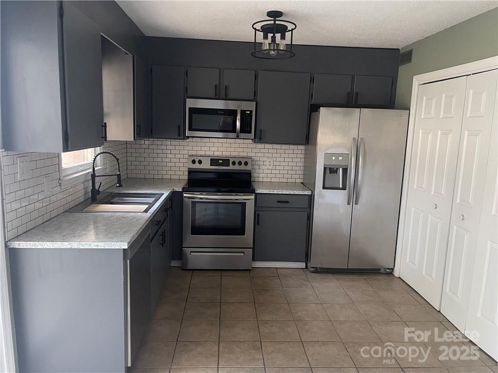1425 20th Avenue Northeast Hickory, NC 28601 - Photo 5 of 22 a kitchen with stainless steel appliances granite countertop a sink stove and refrigerator