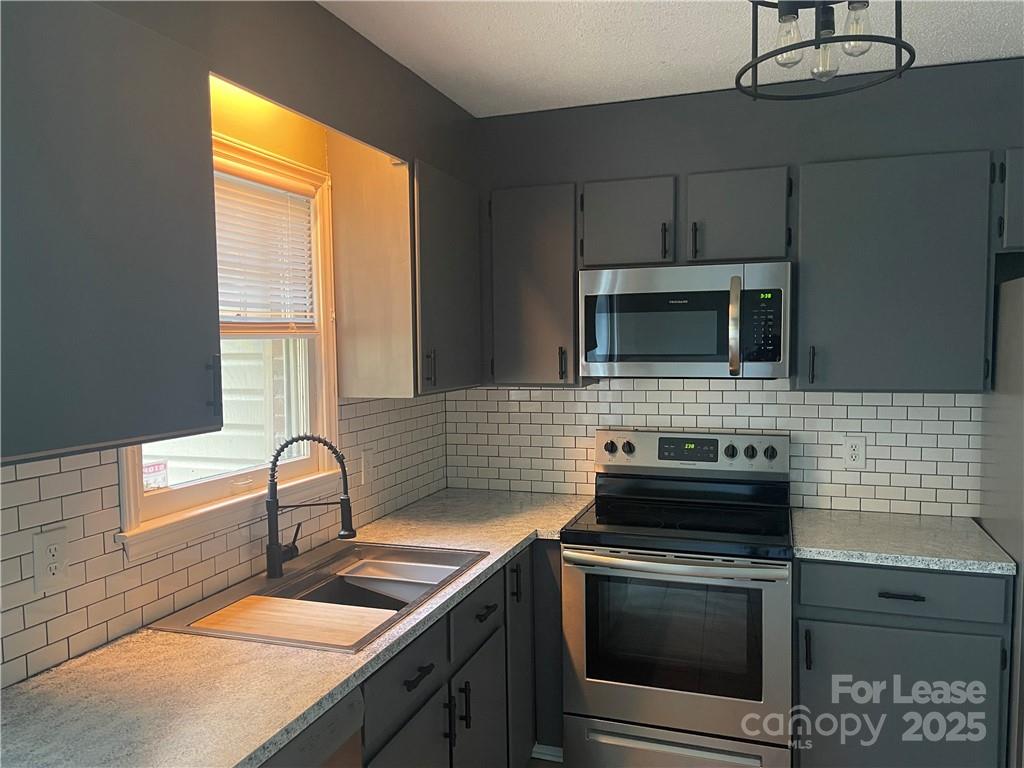 1425 20th Avenue Northeast Hickory, NC 28601 - Photo 6 of 22 a kitchen with a sink stove and microwave