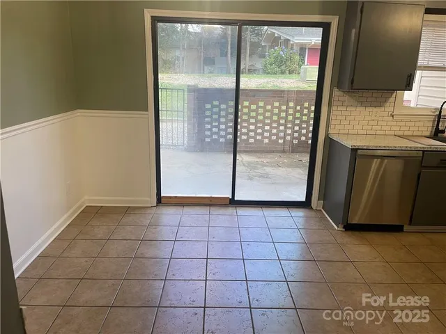 a view of a refrigerator in kitchen and an empty room