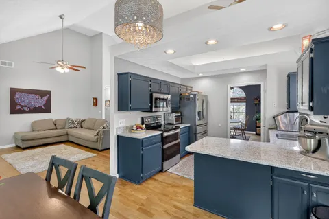 a living room with furniture kitchen and a chandelier