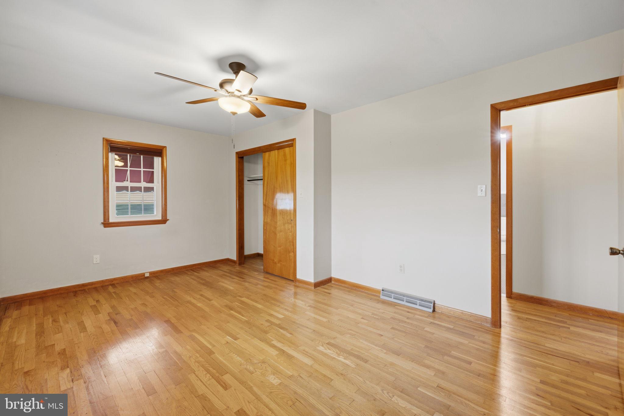 14983 Charles Town Road Charles Town, WV 25414 - Photo 25 of 80 a view of an empty room with wooden floor and a ceiling fan