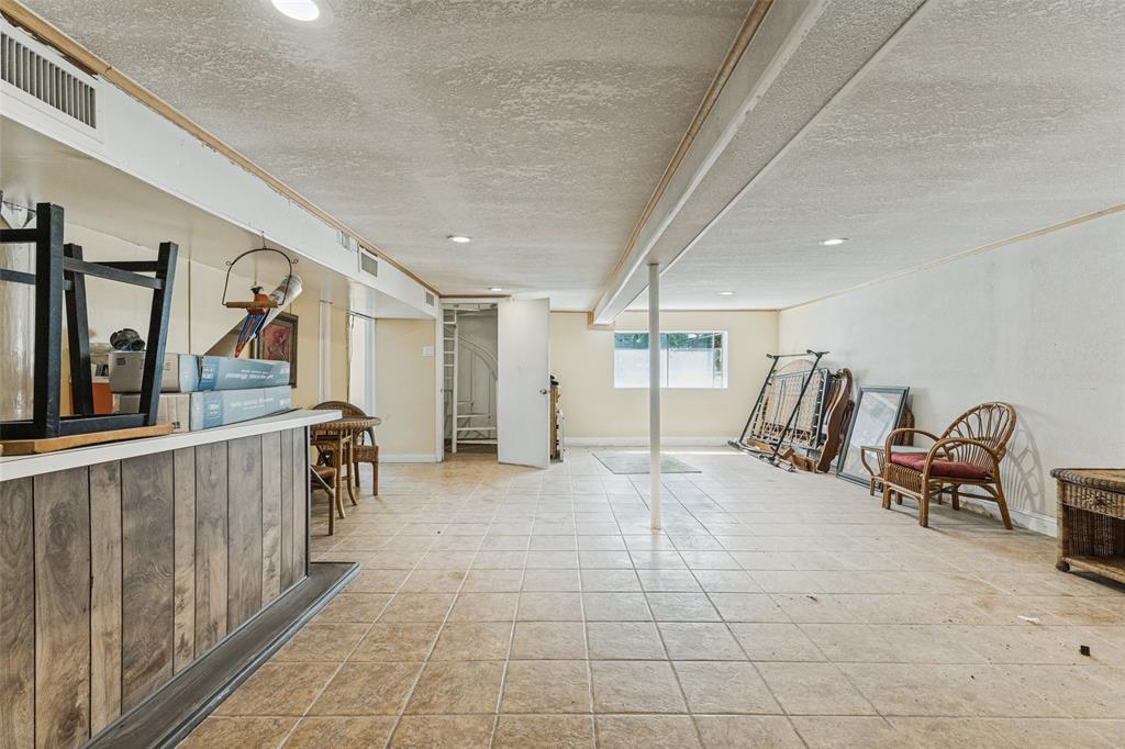 12960 Gantt Road East Azle, TX 76020 - Photo 15 of 26 Lower level recreation area featuring tile flooring, recessed lighting, and a built-in bar with wood-finish paneling