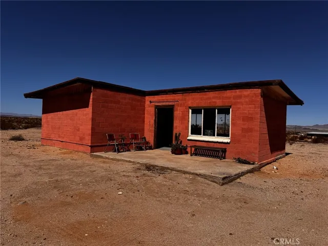a backyard of a house with barbeque oven table and chairs