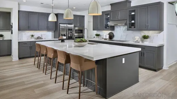 a kitchen with stainless steel appliances kitchen island granite countertop a table chairs sink and cabinets