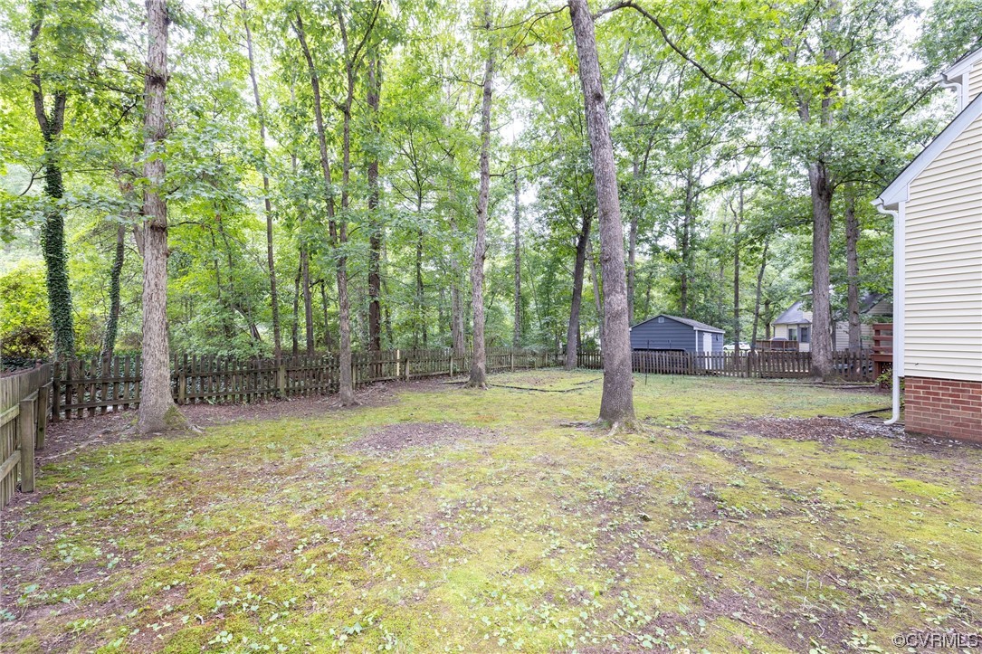 2406 Arrowood Road Midlothian, VA 23112 - Photo 38 of 39 a backyard of a house with lots of plants and large tree
