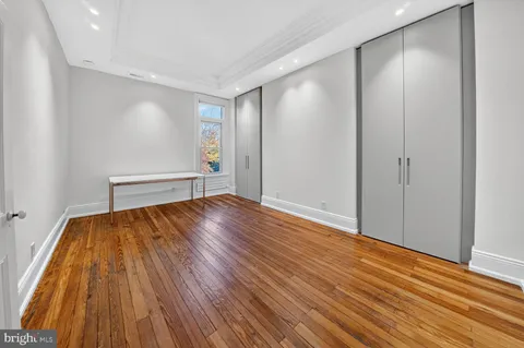 a view of empty room with wooden floor