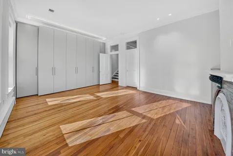 a view of empty room with wooden floor