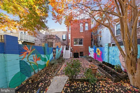 a front view of a house with large trees