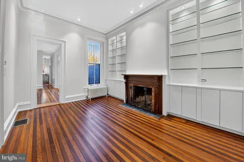 a view of a livingroom with wooden floor and a fireplace