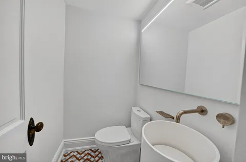 a white toilet sitting next to a shower