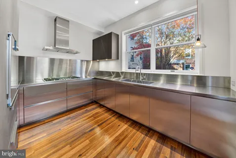 a kitchen with stainless steel appliances granite countertop a sink and wooden cabinets