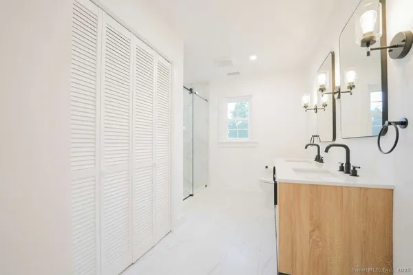 a bathroom with a sink a mirror and a shower