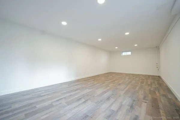 a view of empty room with wooden floor