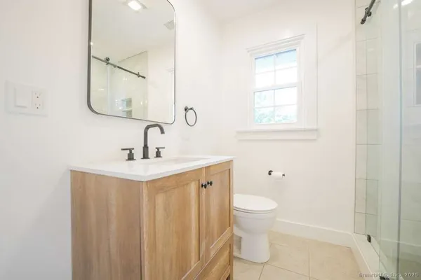 a bathroom with a toilet a sink and a mirror