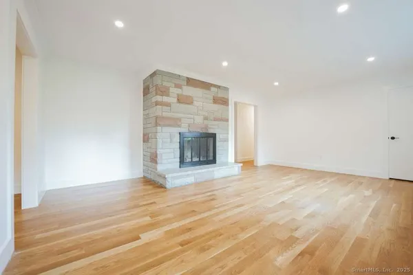 an empty room with wooden floor and fireplace