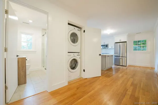 a view of a kitchen with a sink refrigerator and wooden floor