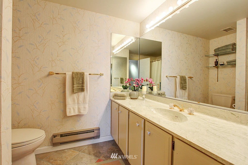 6535 Seaview Avenue Northwest, Unit 601B Seattle, WA 98117 - Photo 11 of 17 a bathroom with a granite countertop sink mirror vanity and toilet