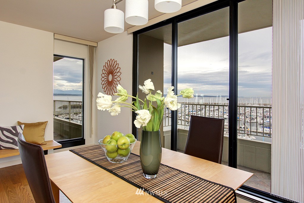 6535 Seaview Avenue Northwest, Unit 601B Seattle, WA 98117 - Photo 3 of 17 a dining room with furniture a potted plant and wooden floor