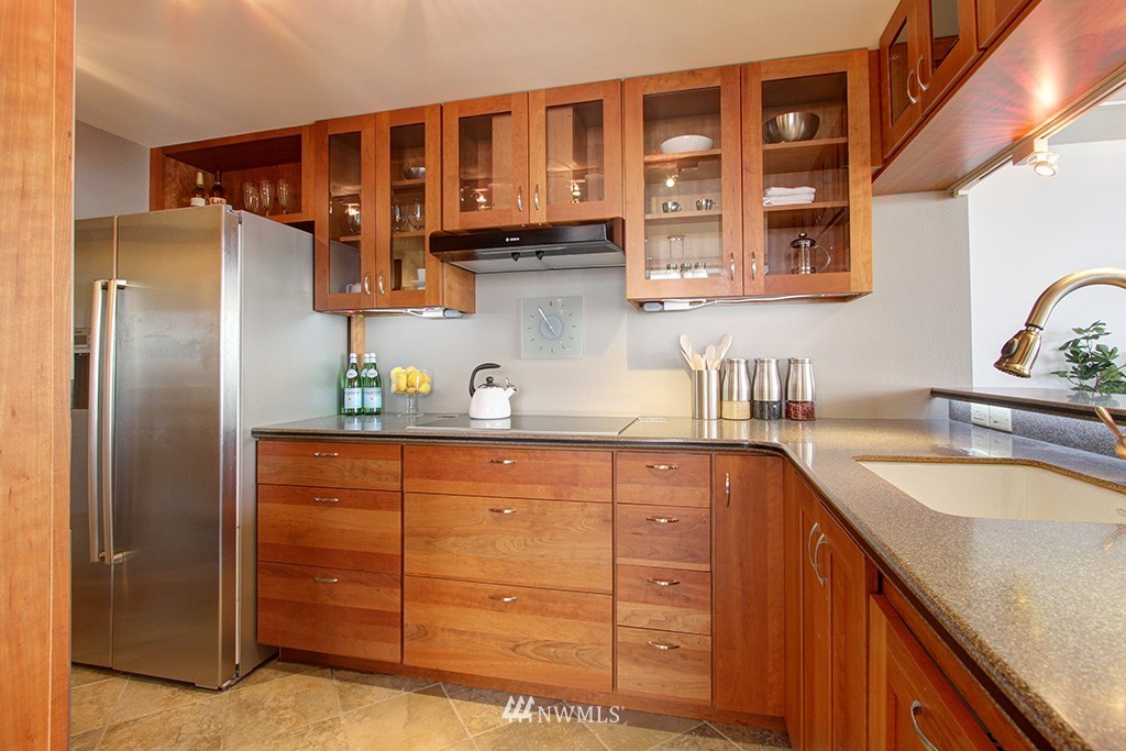 6535 Seaview Avenue Northwest, Unit 601B Seattle, WA 98117 - Photo 5 of 17 a kitchen with stainless steel appliances granite countertop a sink and cabinets