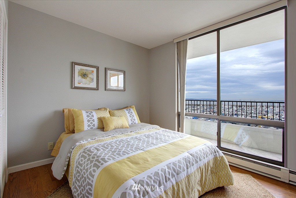 6535 Seaview Avenue Northwest, Unit 601B Seattle, WA 98117 - Photo 10 of 17 a bedroom with a large bed and a balcony view
