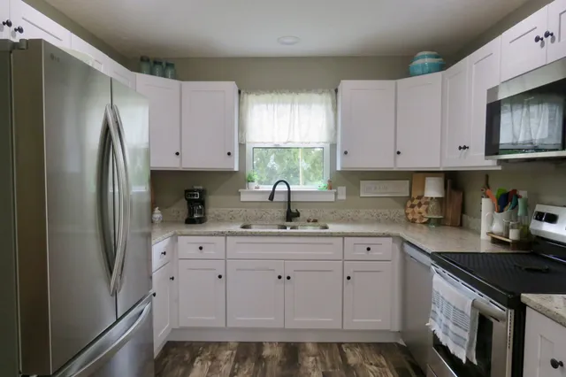 a kitchen with white cabinets and white appliances