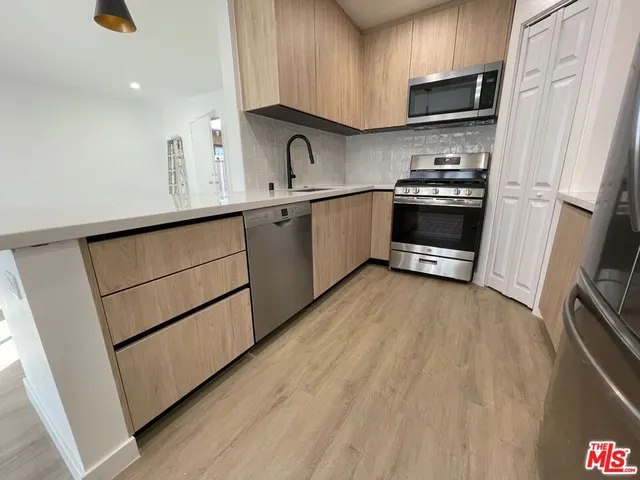 a kitchen with stainless steel appliances a refrigerator sink and microwave