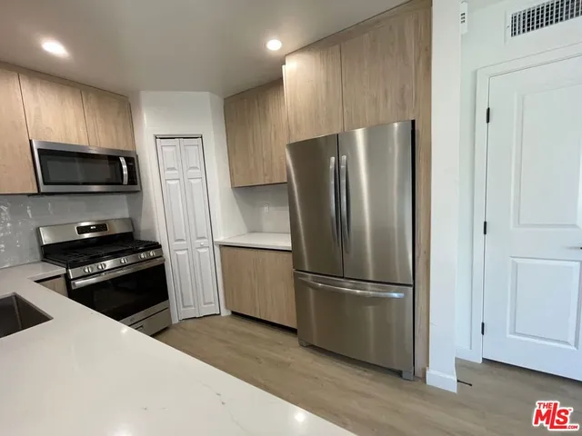 a kitchen with a refrigerator stove and wooden cabinets