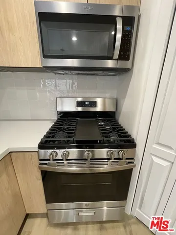 a stove top oven sitting inside of a kitchen