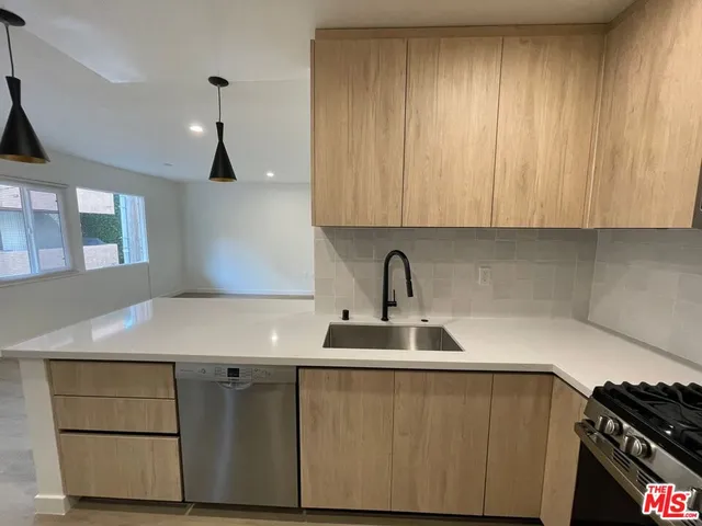 a kitchen with a sink cabinets and appliances