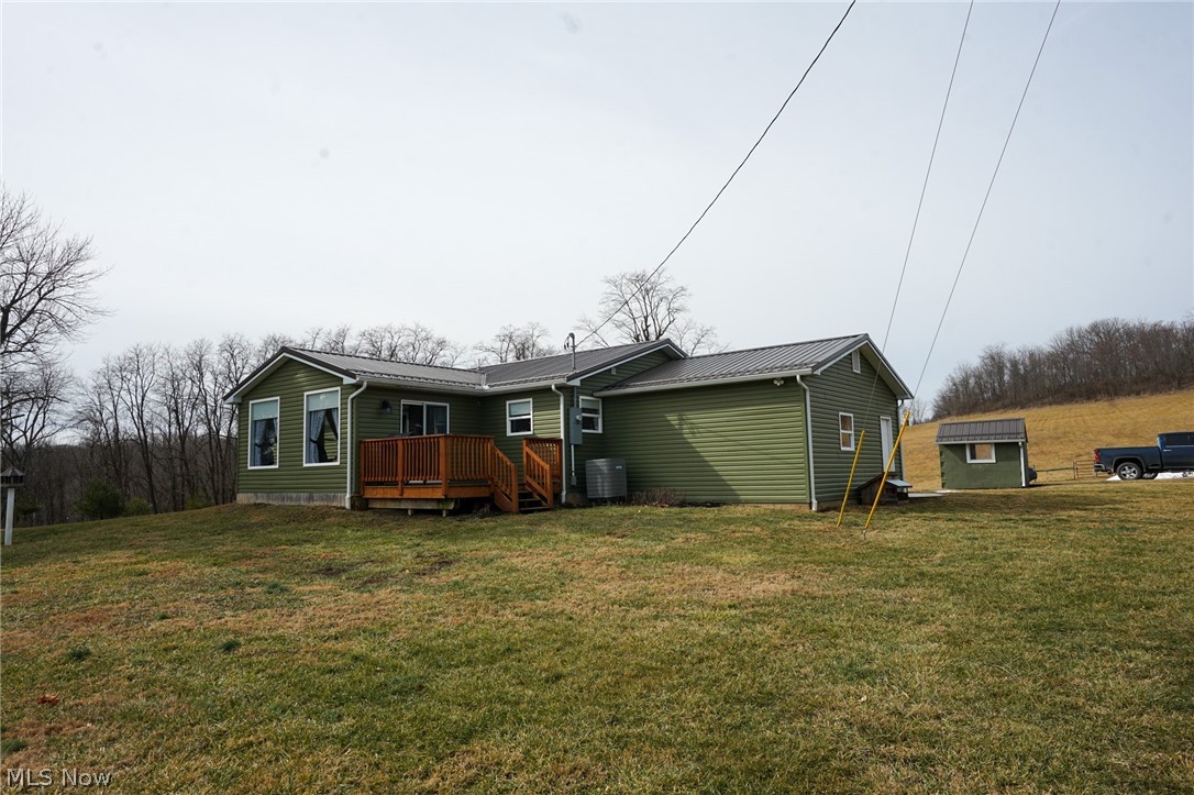 1325 County Line Road Hopewell, OH 43746 - Photo 29 of 45 Back of house featuring a yard, a wooden deck, and a metal roof