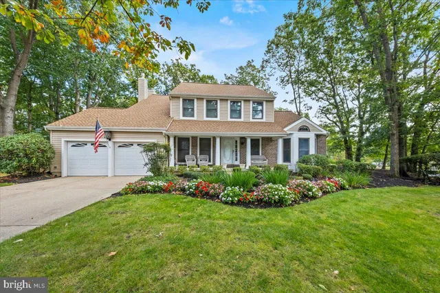 a front view of a house with a garden and plants