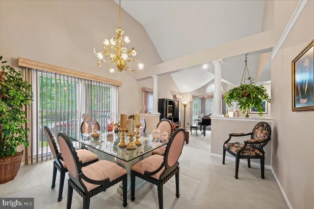 a dining room with furniture a large window and a chandelier