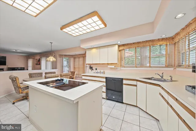 a kitchen that has a lot of cabinets a sink and appliances in it