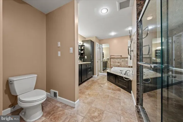 a large bathroom with a granite countertop double vanity sink a large mirror and a bathtub