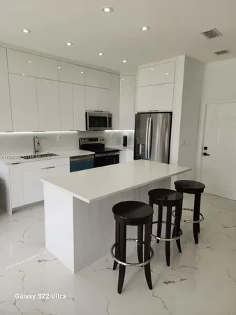 a kitchen with refrigerator and chairs