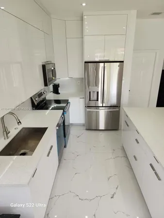 a kitchen with granite countertop a sink stove and refrigerator