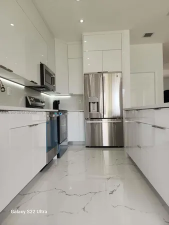 a kitchen with stainless steel appliances granite countertop a refrigerator sink and stove
