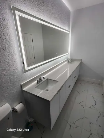 a bathroom with a sink a toilet a shower and a window
