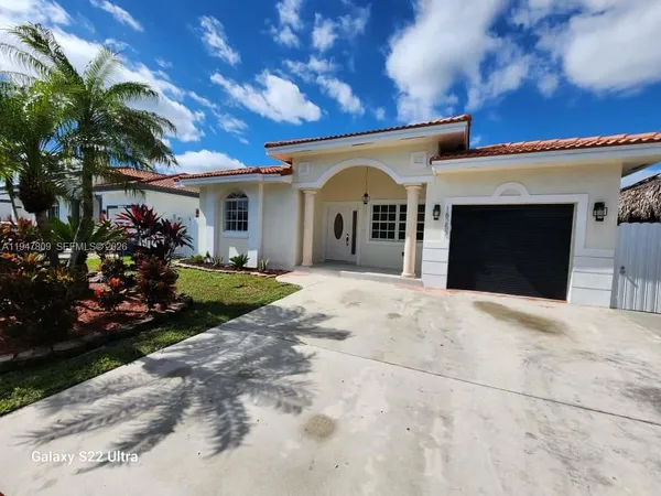 a front view of a house with a garden and plants