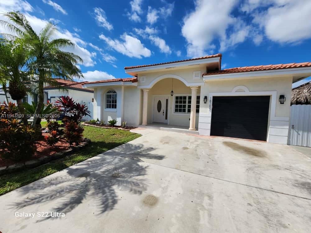 18252 Southwest 146th Avenue Miami, FL 33177 - Photo 3 of 46 a front view of a house with a garden and plants