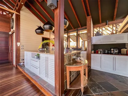 a kitchen with white cabinets and wooden floor