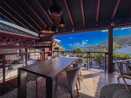 a view of a patio with table and chairs with wooden floor and fence