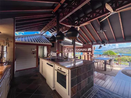 a view of a kitchen with stainless steel appliances granite countertop a stove a sink and a dining table