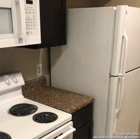 a kitchen with a refrigerator and a stove