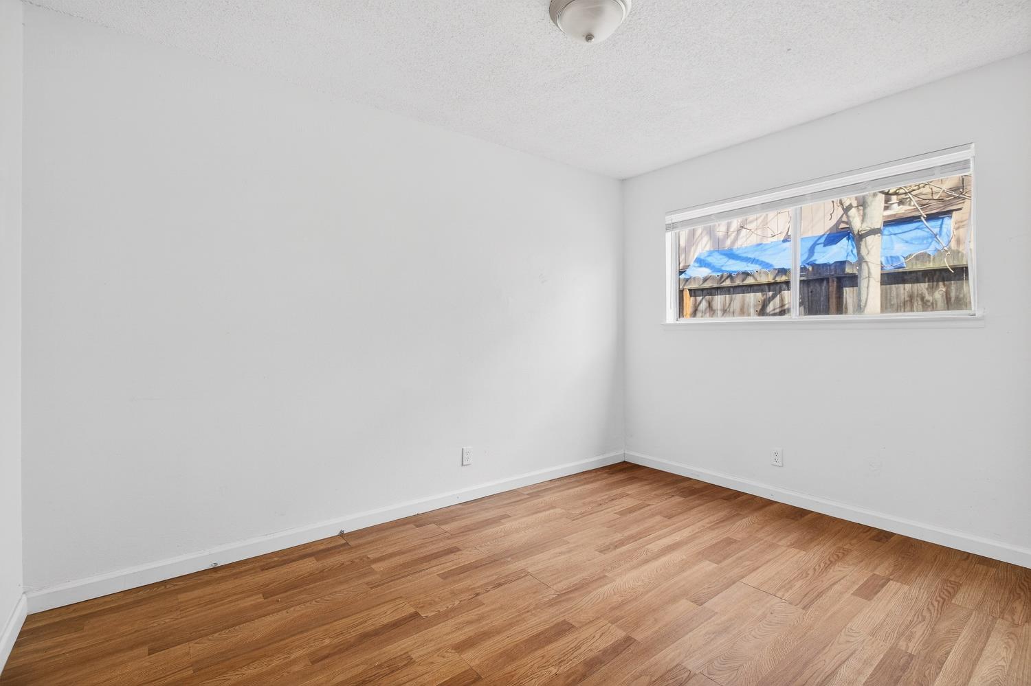 1962 Edwards Avenue Merced, CA 95340 - Photo 17 of 22 a view of an empty room with wooden floor and a window