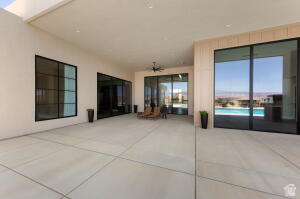 1141 East Lost Ridge Drive Washington, UT 84780 - Photo 108 of 108 Expansive concrete patio area with a covered ceiling, featuring multiple large glass sliding doors and a prominent window with dark framing