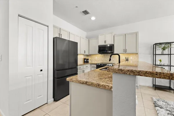 a kitchen with stainless steel appliances granite countertop a stove sink and cabinets