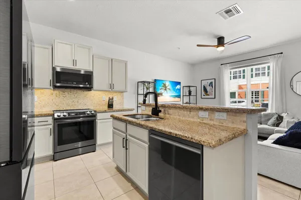 a kitchen with a sink dishwasher a stove and a refrigerator